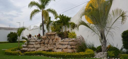 a rock garden in front of a building with palm trees at Hotel Magico Inn in Cuautla Morelos