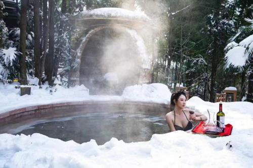 a woman sitting in the snow in front of a fountain at Evergreen Retreat-walk to National Forest Park, free pick up service in Zhangjiajie