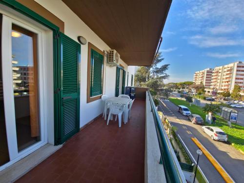 un balcon avec des chaises blanches et une vue sur une rue dans l'établissement La casetta di Francesco - Relax - Mare - Treno 20' Roma, à Marina di Cerveteri