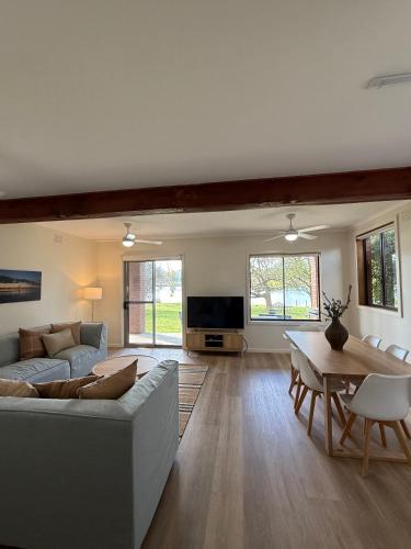 a living room with a couch and a table at Golden Mile - On the Waterfront in Bundalong