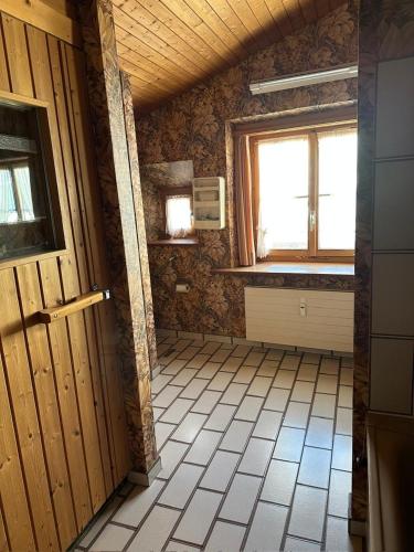 a room with a bathroom with a window and a door at Chasa pin in Müstair