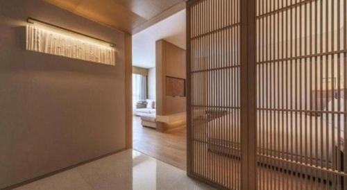 una habitación con una partición con una puerta con una sala de estar en The East Hotel Hangzhou, en Hangzhou
