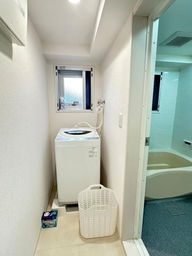 a bathroom with a washer and dryer in a room at 土田501紧邻上野步行6分钟可抵达山手线成田机场直达 in Wada