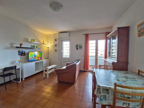 un salon avec une table à manger et une télévision dans l'établissement La casetta di Francesco - Relax - Mare - Treno 20' Roma, à Marina di Cerveteri