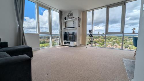 a living room with large windows and a camera at Stylish 2BR Serviced Apartment by Ellbee Apartments in Hemel Hempstead