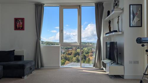 a living room with a large window and a television at Stylish 2BR Serviced Apartment by Ellbee Apartments in Hemel Hempstead