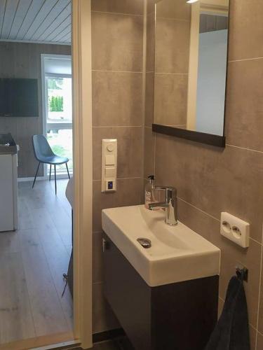 a bathroom with a white sink and a mirror at Stylish Cabin Experience In Beautiful Surroundings in Færvik