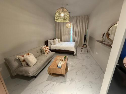 a living room with a couch and a table at The chic Retreat Stylish Studio 2 in Abu Dhabi