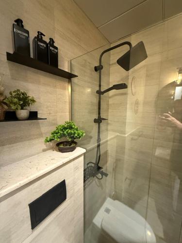 a bathroom with a shower with a toilet in it at The chic Retreat Stylish Studio 2 in Abu Dhabi