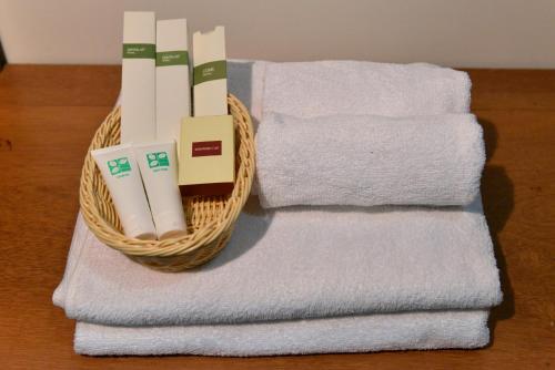 a basket of towels sitting next to a stack of towels at Happy​​ Family Guesthouse in Kampot