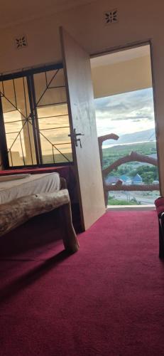 a bedroom with a bed and a window with a red carpet at Eagle Nest lake Natron Guest House in Mtowabaga