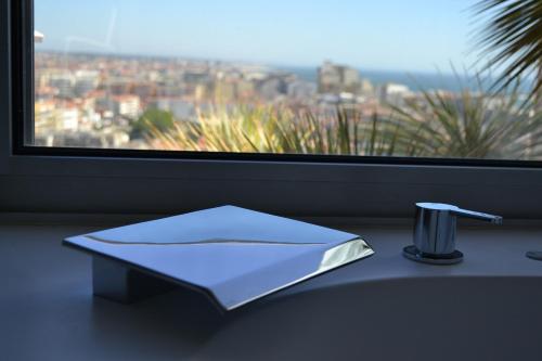 a white napkin sitting on a counter next to a window at Hotel Costa Verde in Póvoa de Varzim