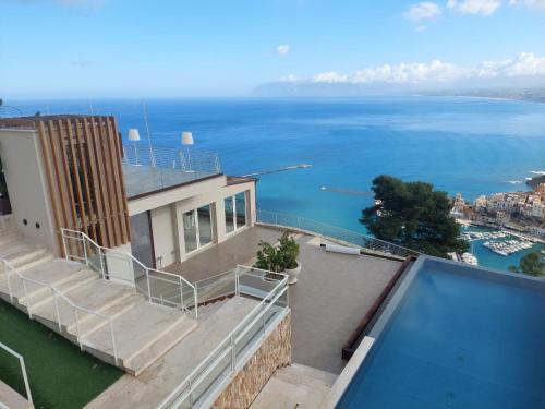 a house with a balcony with a view of the water at Hotel Belvedere Resort in Castellammare del Golfo