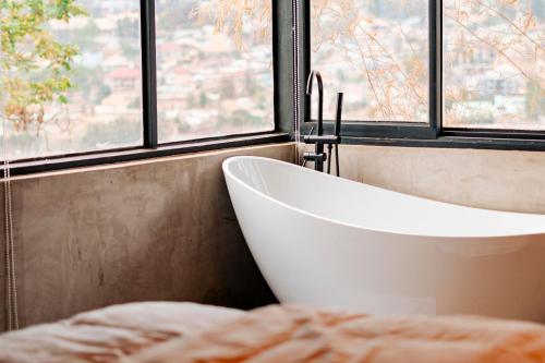 a bath tub in a bathroom with a window at Ndare Eco Ville in Kigali