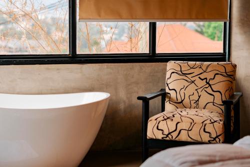 a bathroom with a chair and a tub and a window at Ndare Eco Ville in Kigali