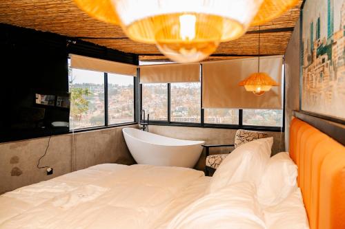 a bedroom with a large bed and a bath tub at Ndare Eco Ville in Kigali