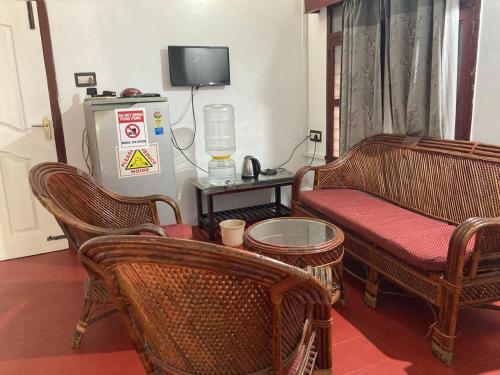 a living room with wicker chairs and a couch at White Villa Guest House in Puducherry