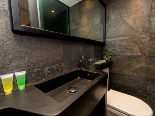 a bathroom with a sink and a toilet and a mirror at Noble Park Hotel in Hong Kong