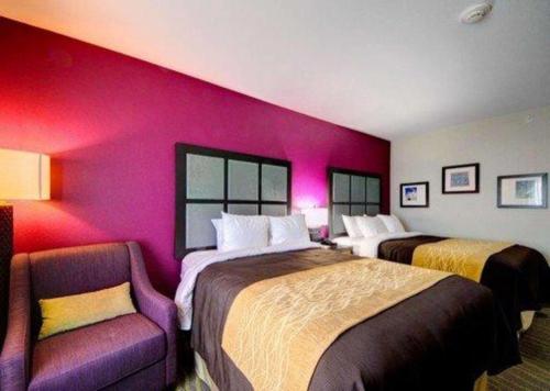 a hotel room with two beds and a chair at Comfort Inn & Suites Tulsa I-44 West - Rt 66 in Tulsa