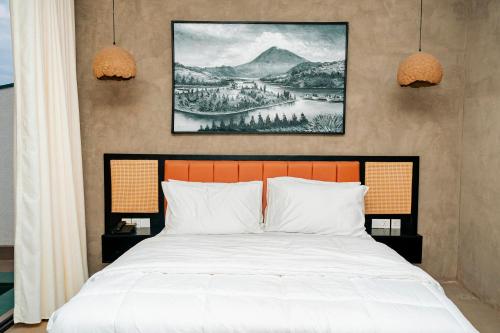 a bedroom with a bed and a painting on the wall at Ndare Eco Ville in Kigali