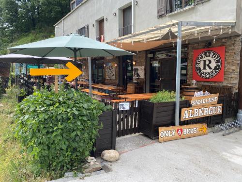 un restaurante con mesas y sombrillas frente a él en Vagabond Vieiras Beds & Communal Dinner Albergue LE-210, en La Portela de Valcarce