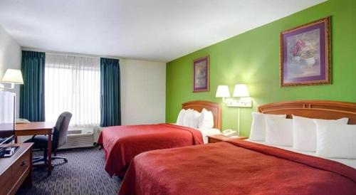 a hotel room with two beds and a desk at Quality Inn & Suites Airport in Austin