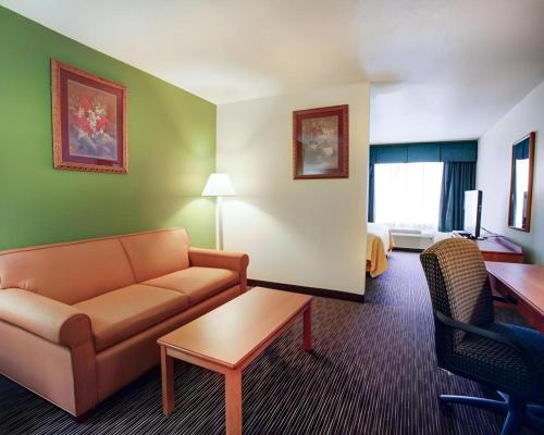 a living room with a couch and a table in a hotel room at Quality Inn & Suites Airport in Austin
