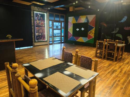 a dining room with a table and chairs and a painting at Hotel OPM in Agra