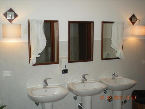 un bagno con tre lavandini e due specchi di Bike-Hotel Abete a San Giovanni Rotondo