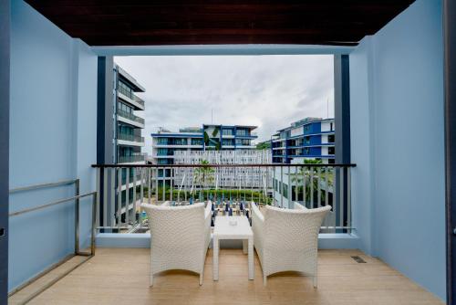 a balcony with chairs and a table with a view at BlueSotel Krabi AoNang Beach in Ao Nang Beach