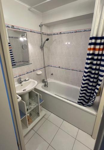 a bathroom with a sink and a tub and a toilet at Le Jean Bart front de mer in Le Crotoy