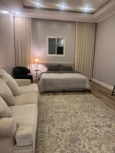 a bedroom with a bed and a couch at بستان الأحلام in Abha