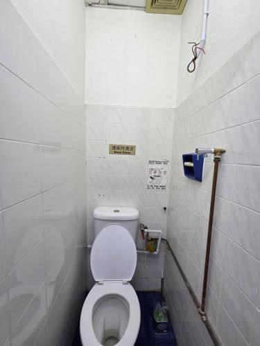 Un baño con un inodoro blanco en una cabina. en Mingle 7 Hostel Georgetown Penang, en George Town
