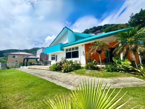 a house with a blue roof and a green yard at Sunset Villa Shirahama 5 min to the beach Pets OK in Shimoda
