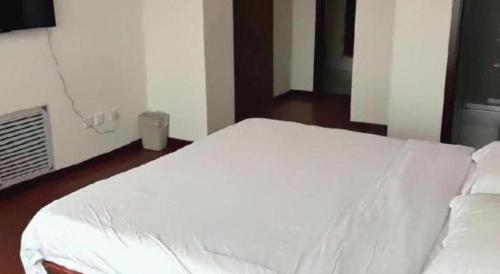 a large white bed in a room with at GreenTree Inn Weihai Liugongdao Wharf Qingdao North Road Express Hotel in Weihai