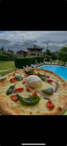 a pizza sitting on a table next to a pool at Park Hotel Val Di Monte ***S in Malcesine