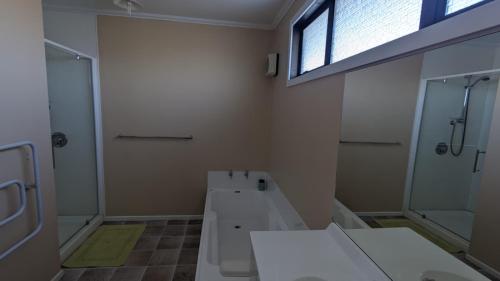 a bathroom with a toilet and a shower and a sink at Polka Apartment in Ranfurly
