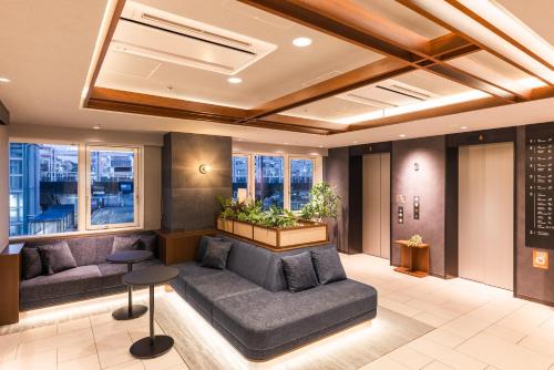 a lobby with a couch and chairs in a building at Sotetsu Fresa Inn Yokohama Totsuka - Renovated in March 31st 2025 in Yokohama