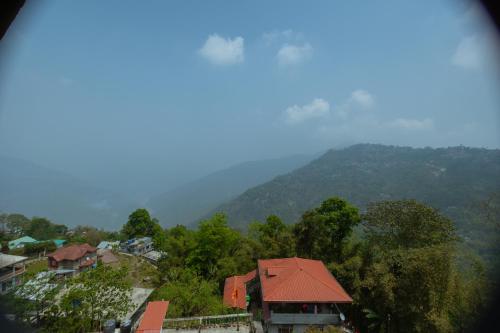 a house with a red roof on a mountain at Divyaraa Breathing Stone in Kalimpong