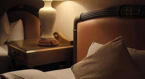 a lamp on a night stand next to a bed at Hotel de Premiere Minowa in Inawashiro