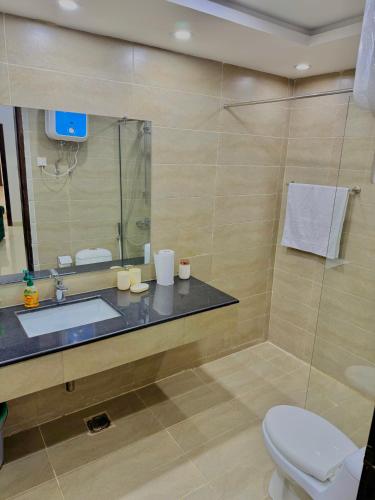a bathroom with a sink and a toilet and a mirror at Dahlia By T2R, 3BHK Bahria Town Phase 7, Close To DHA-1 Islamabad in Rawalpindi