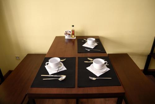 a wooden table with plates and utensils on it at Hotel Villa De Ribadeo in Ribadeo