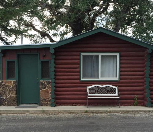 a red house with a bench in front of it at Z Bar Motel in Buffalo