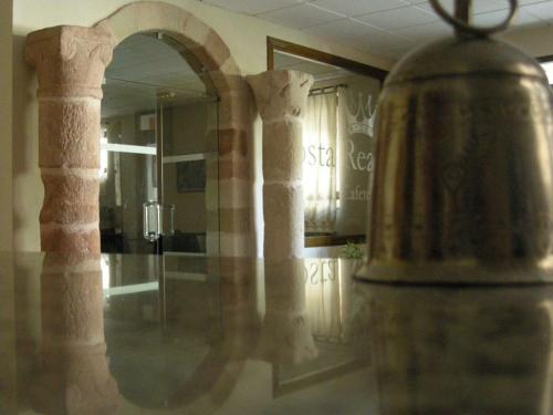 a reflection of a room with a mirror and some columns at Hotel Posta Real in Sigüenza