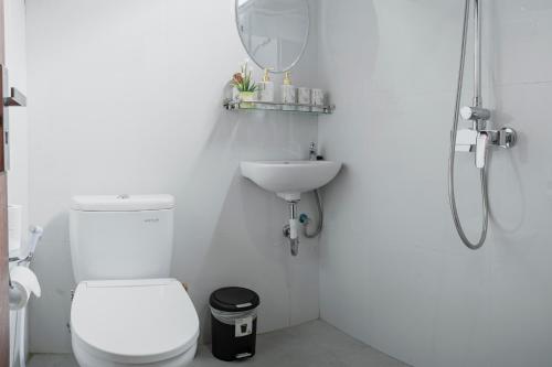 Un baño blanco con inodoro y lavabo. en TRIPLET VILLA Ubud, en Tegalalang