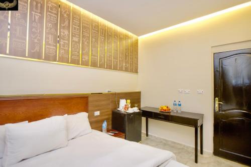 a hotel room with a bed and a desk and a chalkboard wall at Comfort Sphinx & Pyramids Inn in Cairo