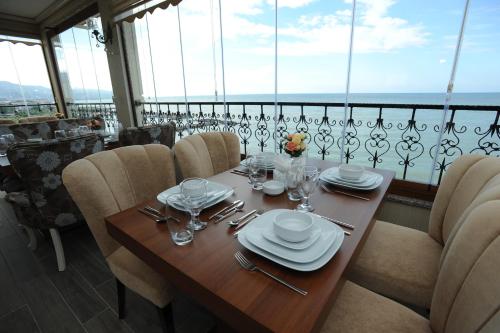 a wooden table with plates and glasses on a balcony at Vurna Butik Hotel in Trabzon