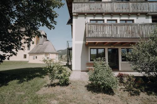 a large white house with a balcony on top of it at Stöckelwohnung, Ferien im Grünen in Aigen im Ennstal