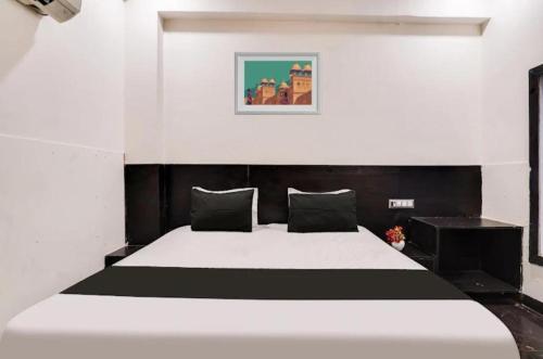 a bedroom with a large bed with black and white sheets at Hotel OPM in Agra