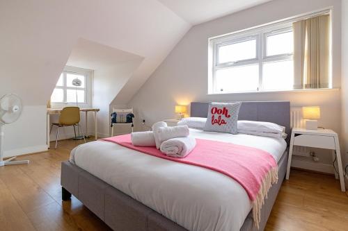 a bedroom with a large bed with towels on it at 2nd Floor Town Centre Apt with FREE Parking in Loughborough